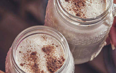 Creamy Christmas Eggnog in 2 glass jars from above with cinnamon sprinkled on top