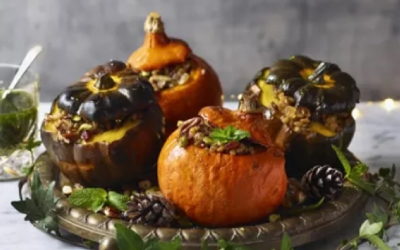 Vegan Roast Squash with cut tops stuffed with nuts and sitting on a serving platter